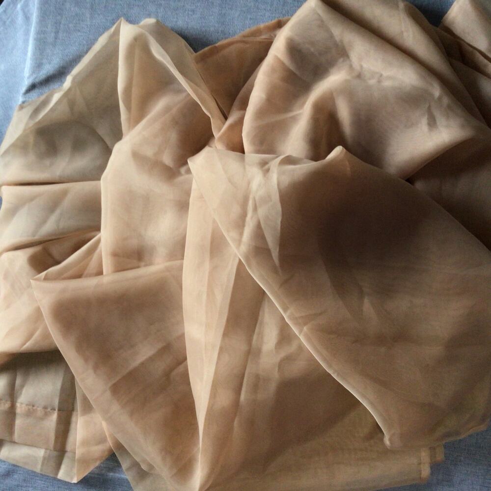 Two sheer terra-cotta rod pocket curtain panels